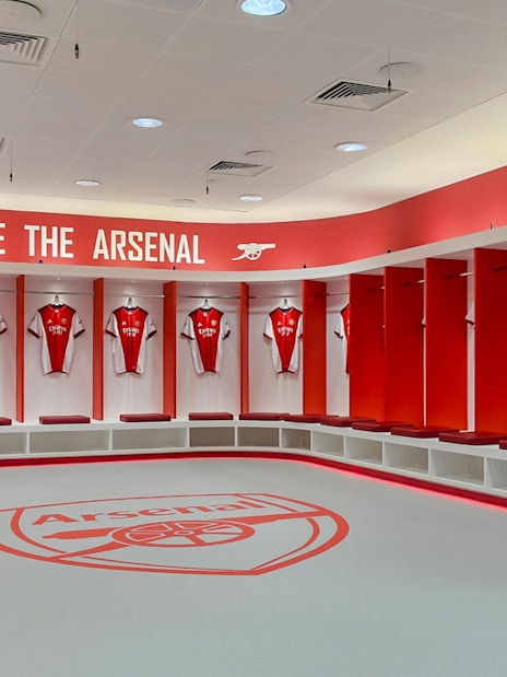 Arsenal FC locker room with jerseys at Emirates Stadium.