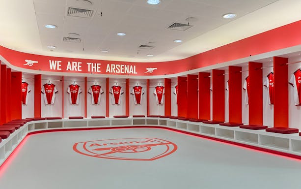 Arsenal FC locker room with jerseys at Emirates Stadium.