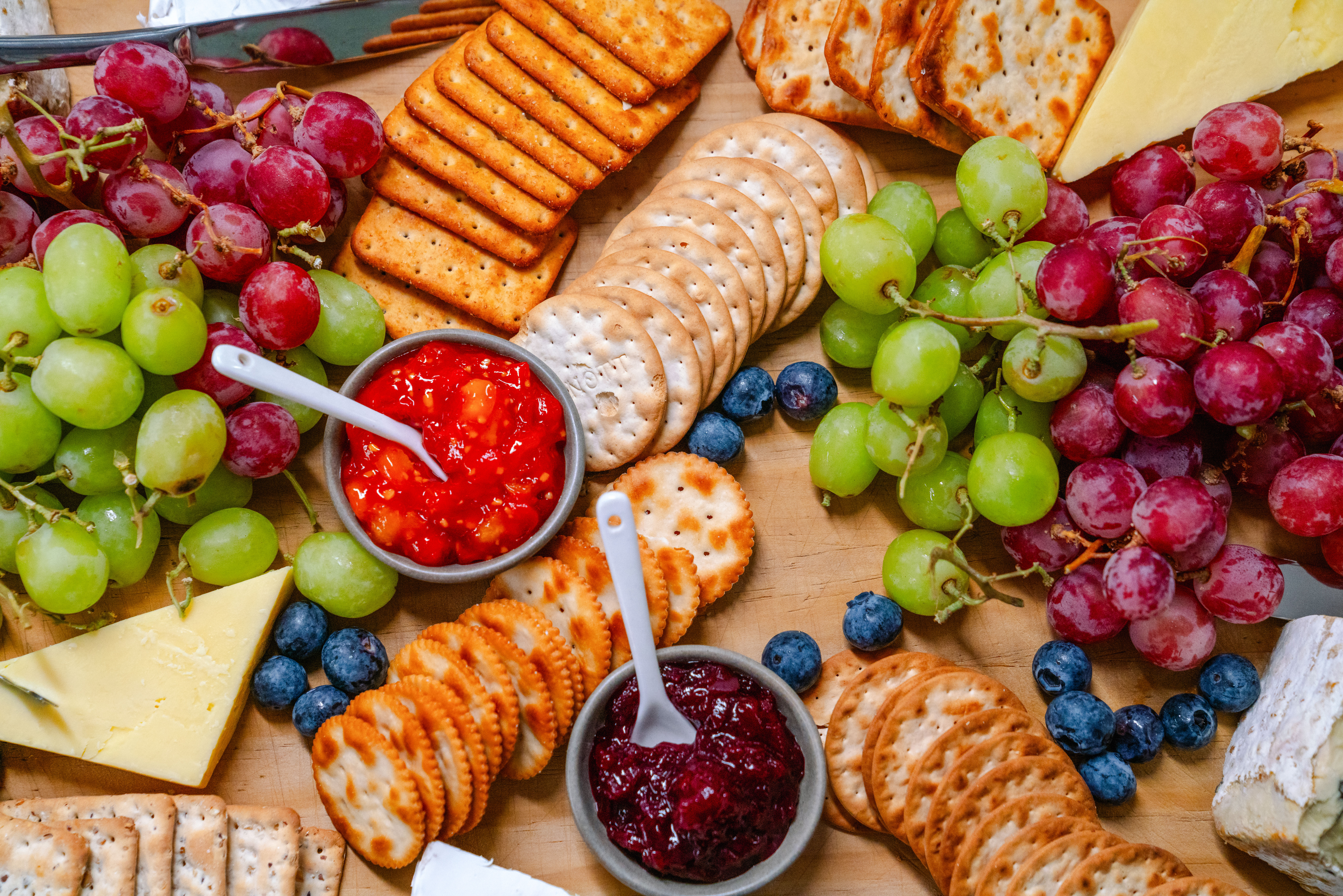 Platter with grapes, crackers, cheeses, and dips for guests on the cruise.