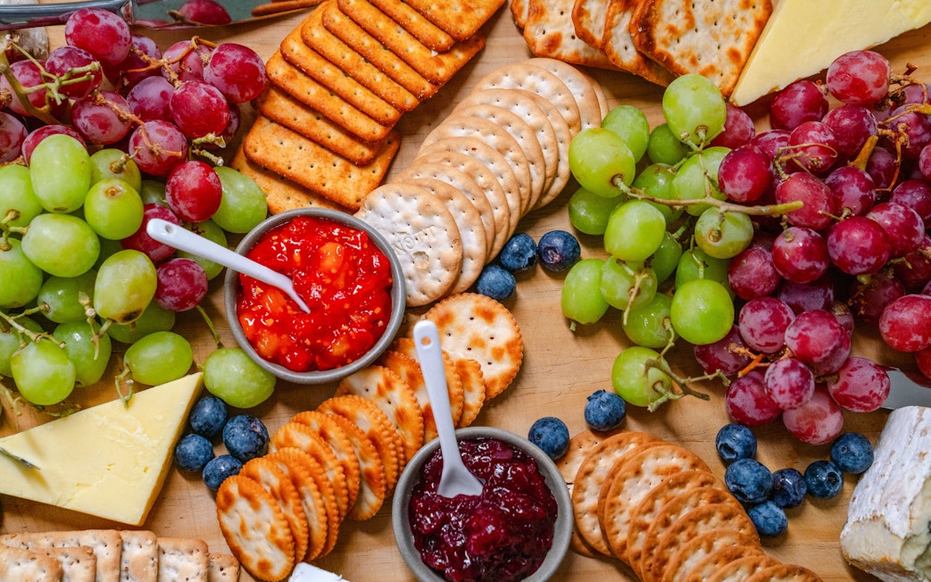 Platter with grapes, crackers, cheeses, and dips for guests on the cruise.