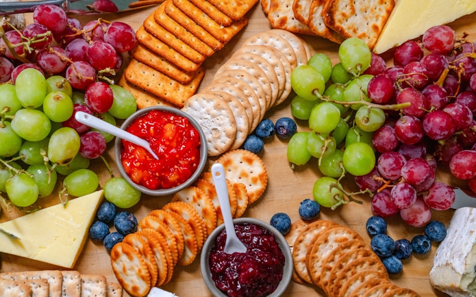 Platter with grapes, crackers, cheeses, and dips for guests on the cruise.
