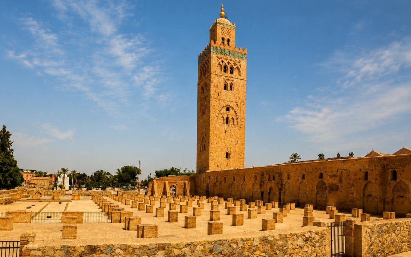 Koutoubia Mosque tower in Marrakech under a clear blue sky.