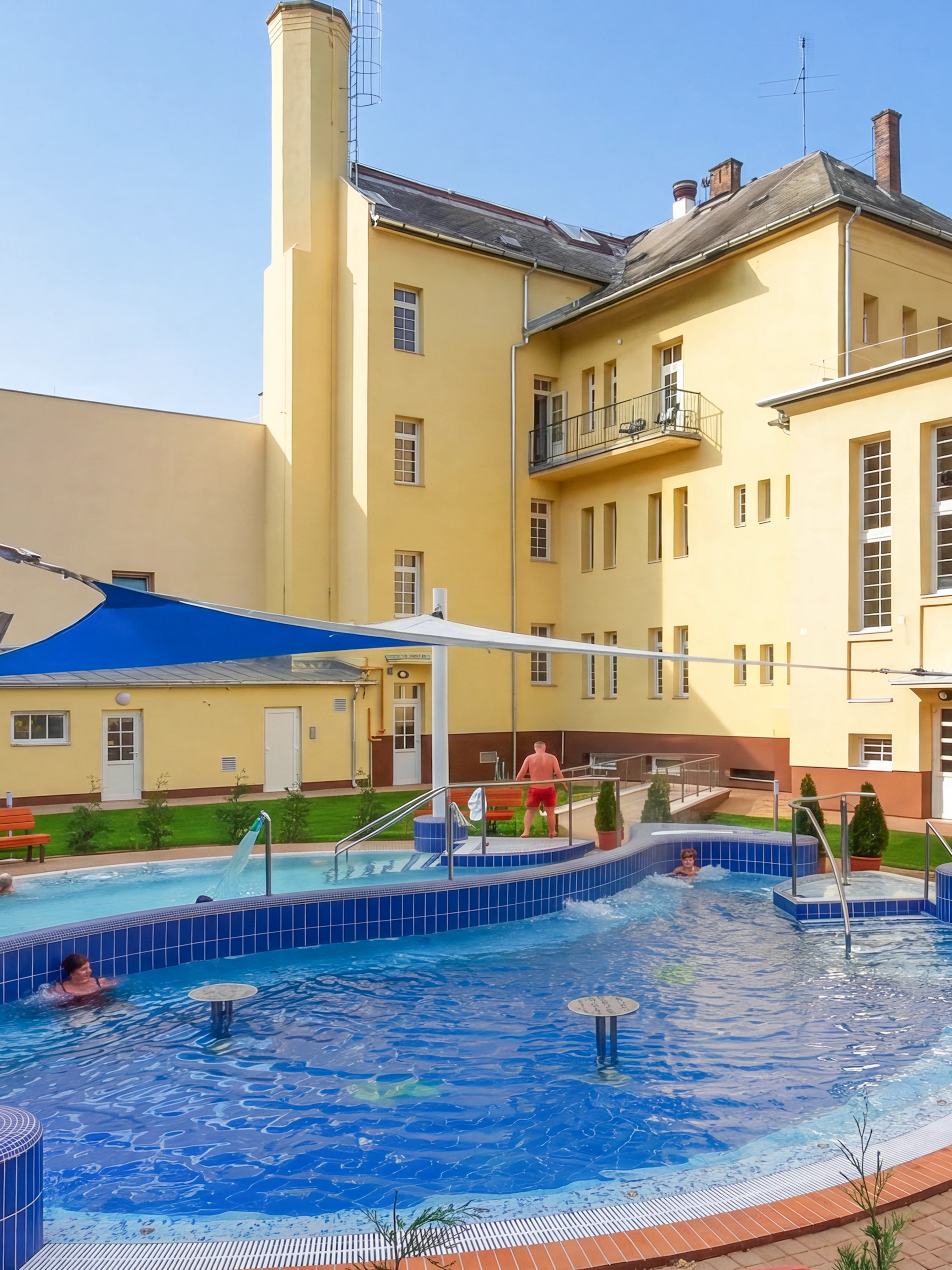 Outdoor pool area at Dandar Spa with people relaxing in the water.
