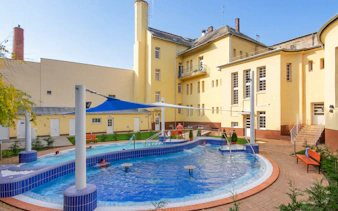 Outdoor pool area at Dandar Spa with people relaxing in the water.