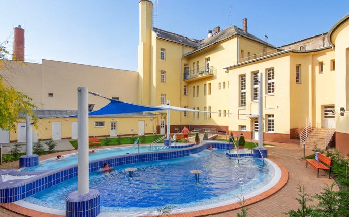Outdoor pool area at Dandar Spa with people relaxing in the water.