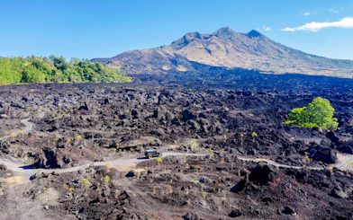 Off-road vehicle on black lava field near Mount Batur, Bali.