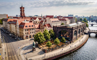 Berlin cityscape with historic buildings and a riverside brewery, part of the Oktoberfest walking tour.