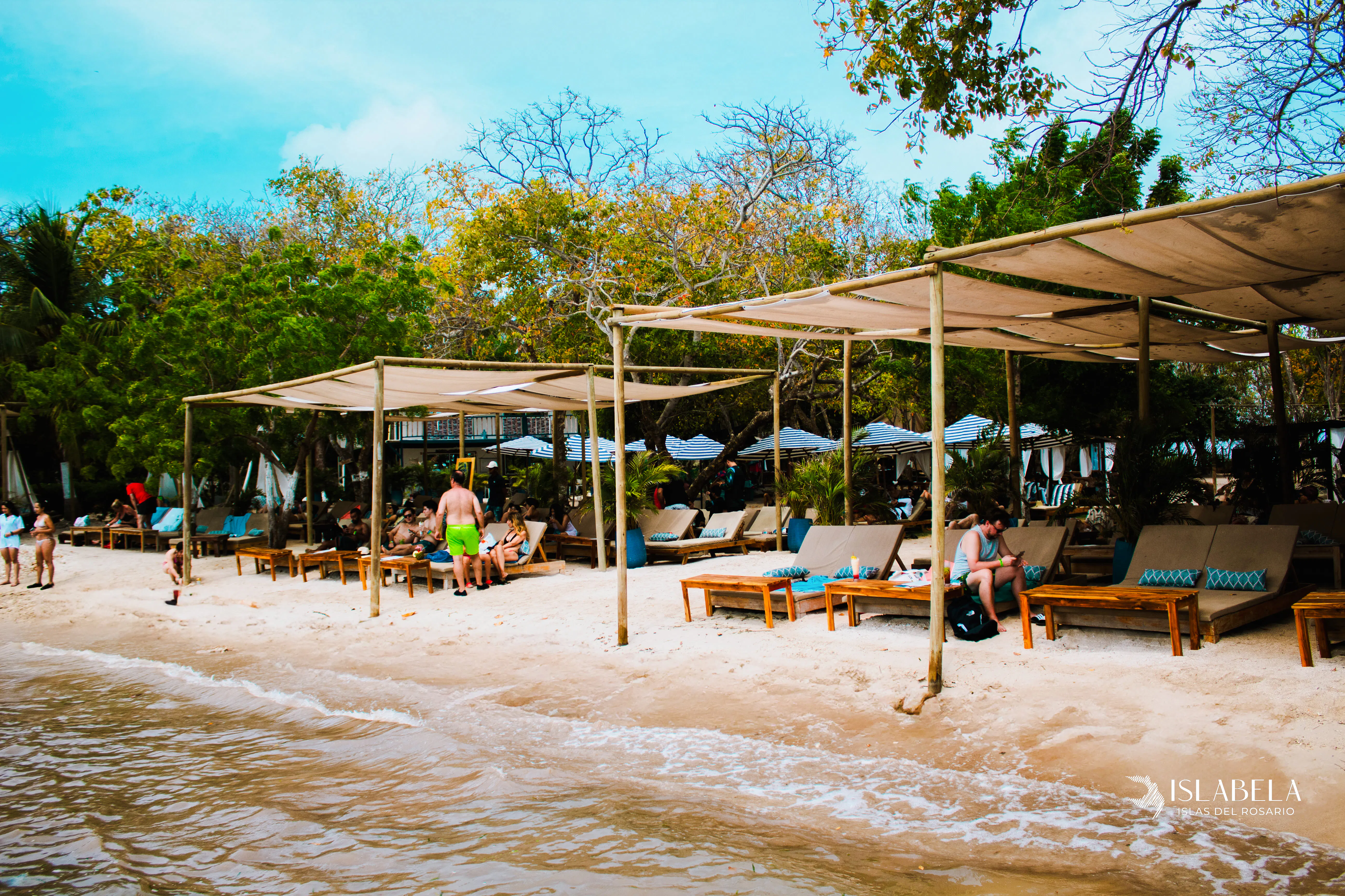 Beachfront lounge area with sunbeds and shade structures on Rosario Islands, Cartagena.
