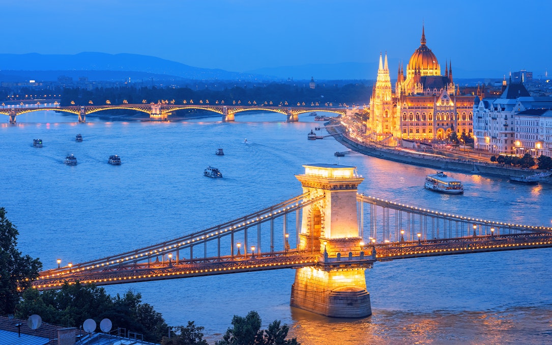 Chain Bridge and Hungarian Parliament illuminated on Danube River, Budapest evening, Hungary.