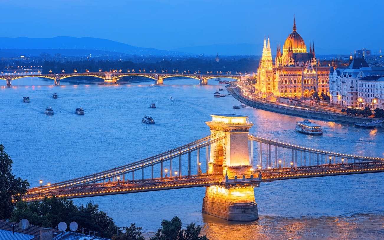 Chain Bridge and Hungarian Parliament illuminated on Danube River, Budapest evening, Hungary.