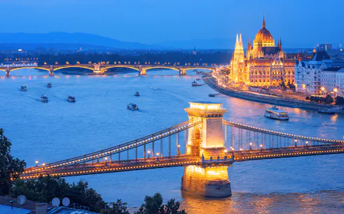 Chain Bridge and Hungarian Parliament illuminated on Danube River, Budapest evening, Hungary.