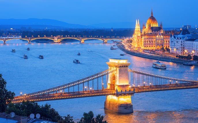 Chain Bridge and Hungarian Parliament illuminated on Danube River, Budapest evening, Hungary.