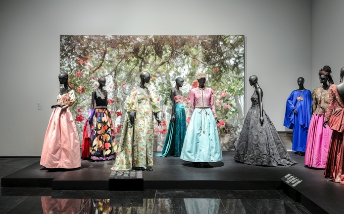 Fashion exhibit at YSL Museum in Marrakech showcasing colorful designer dresses.
