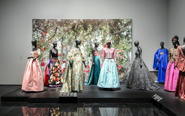 Fashion exhibit at YSL Museum in Marrakech showcasing colorful designer dresses.