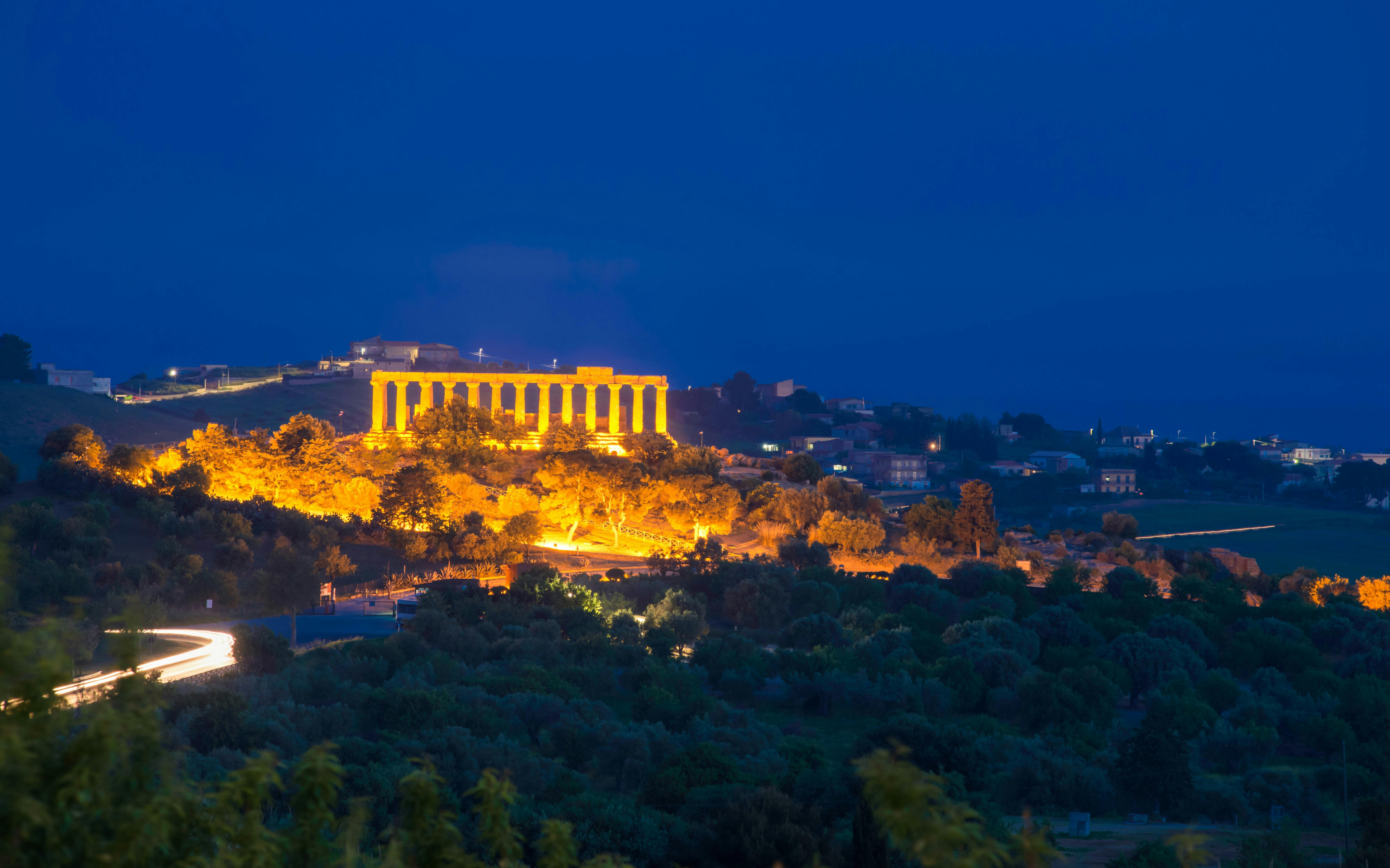Light trail leading to illuminated Temple Valley, Agrigento at night.