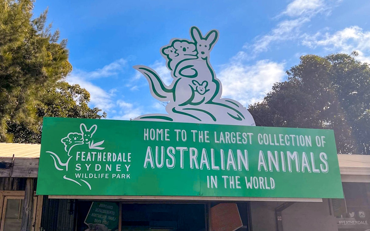 Featherdale Sydney Wildlife Park entrance sign with kangaroo illustration.