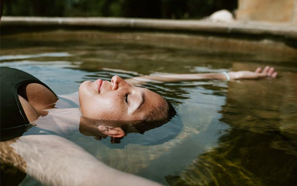 Person relaxing in a hot spring pool on the Mornington Peninsula tour.