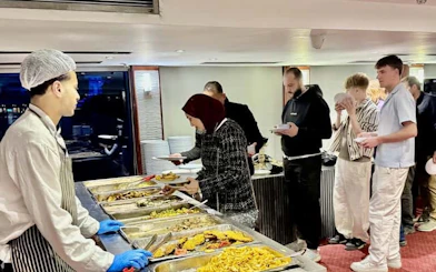 Guests serving themselves at a buffet on a Cairo Nile dinner cruise.