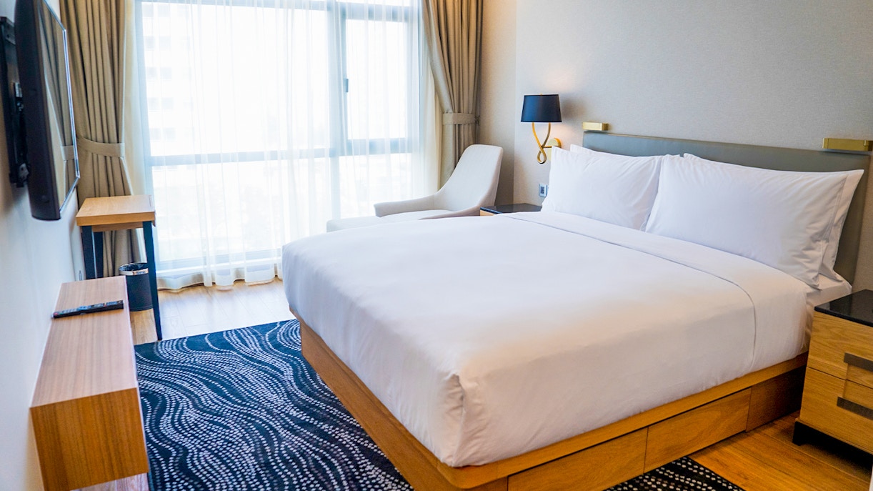 Budget-friendly hotel room with double bed, modern decor, and large window.
