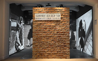 Brick wall with historical images projected, part of Jewish Heritage Tour in Buenos Aires.