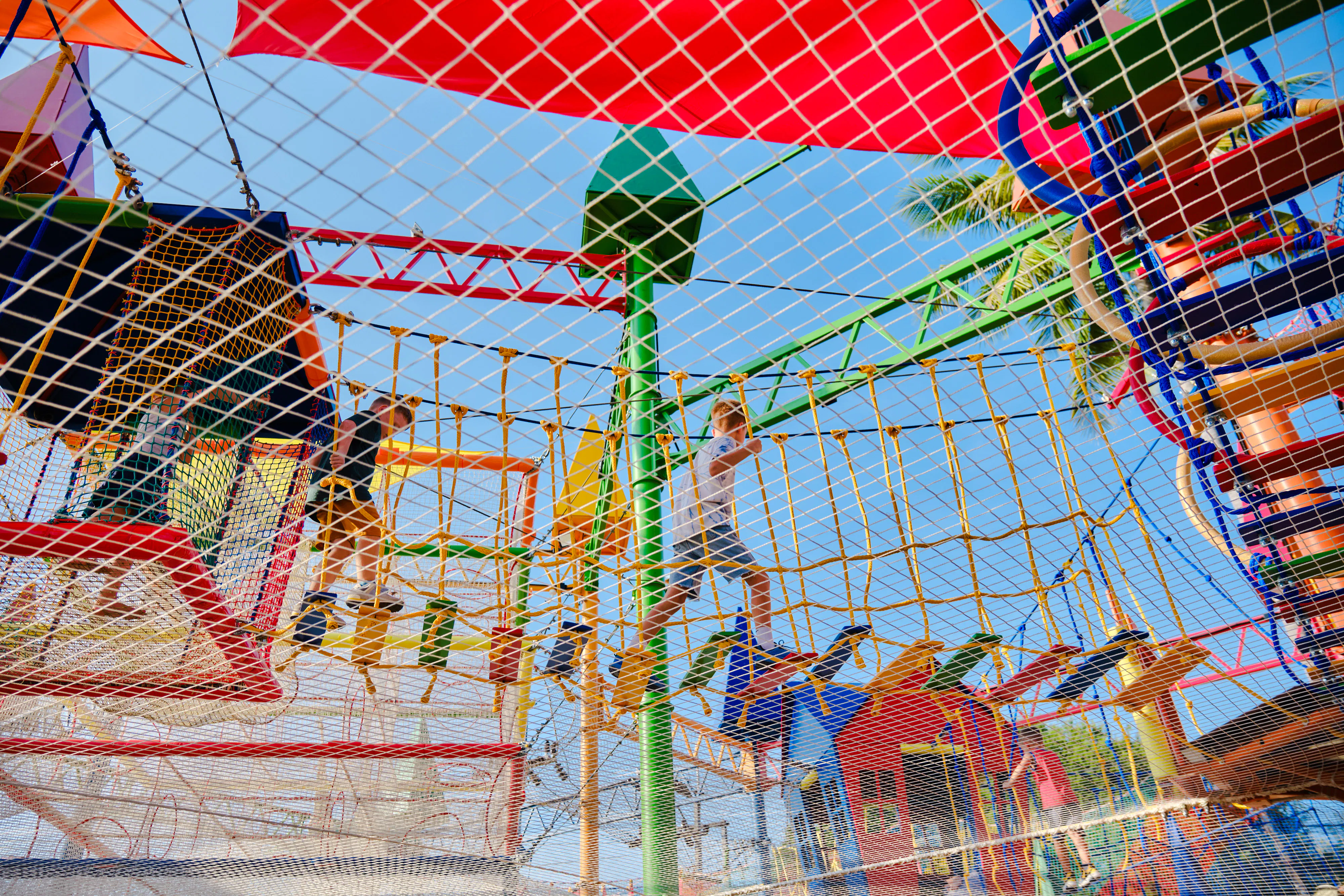 Children navigating a colorful rope course at a birthday party in Phuket.