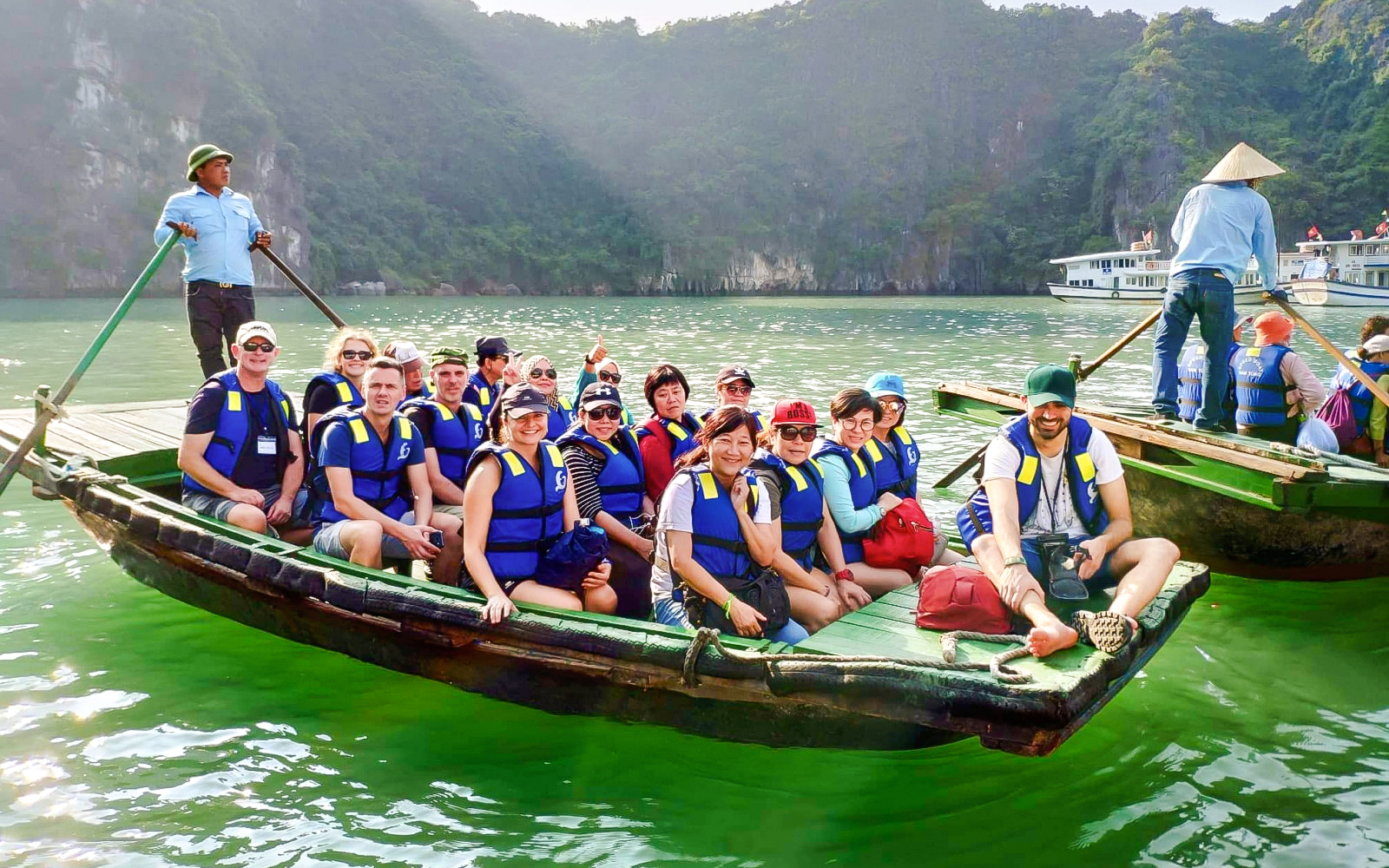 Tourists in a rowboat with a guide exploring Ha Long Bay, Vietnam.