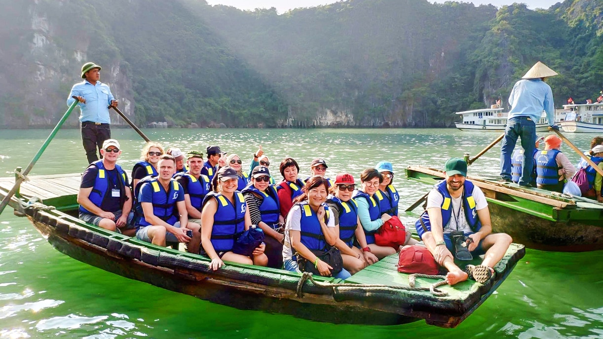 Tourists in a rowboat with a guide exploring Ha Long Bay, Vietnam.