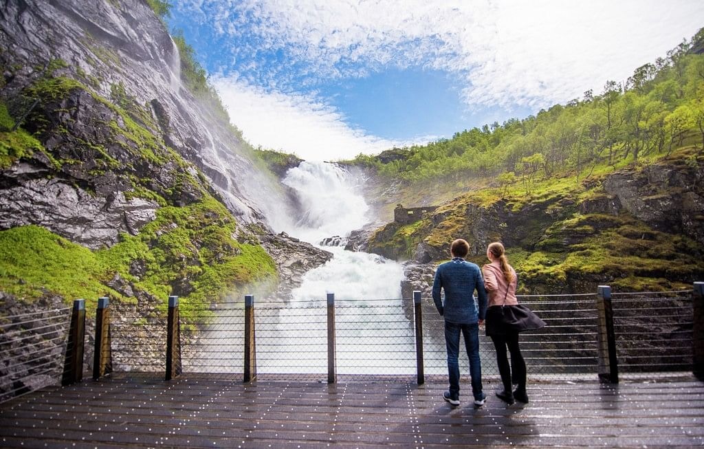 Couple viewing Kjosfossen Waterfall on a guided fjords tour in Norway.