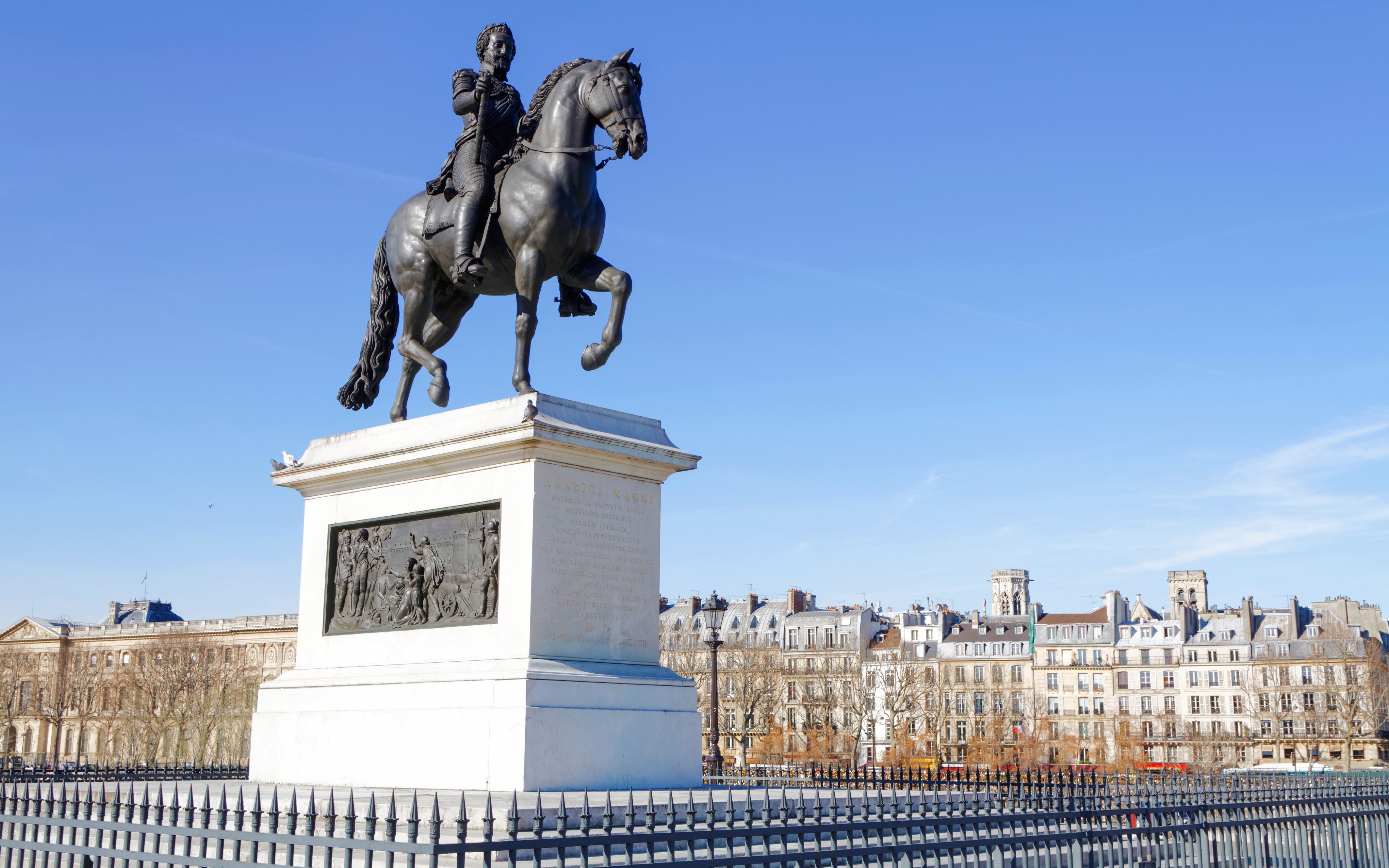 Equestrian statue of Henri IV at Square du Vert-Galant, Paris, with historic buildings in the background.