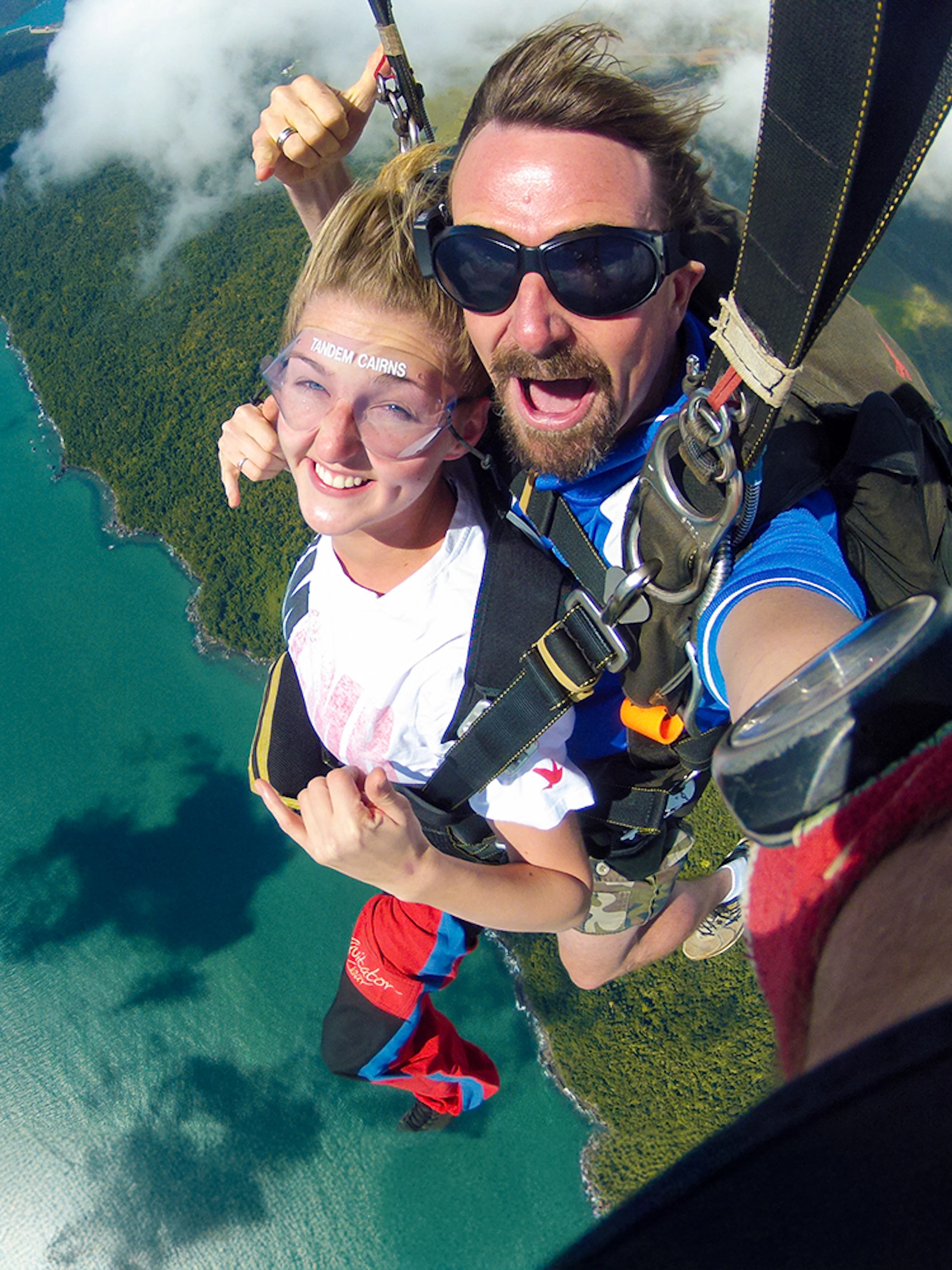 Tandem skydive over Cairns coastline with ocean and forest views.