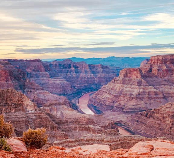 Grand Canyon view with layered rock formations and Colorado River below.