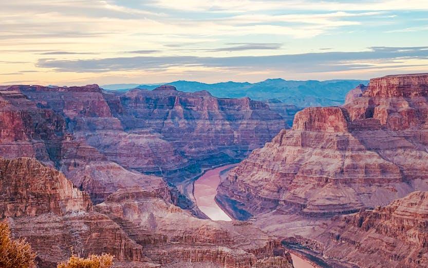 Grand Canyon view with layered rock formations and Colorado River below.