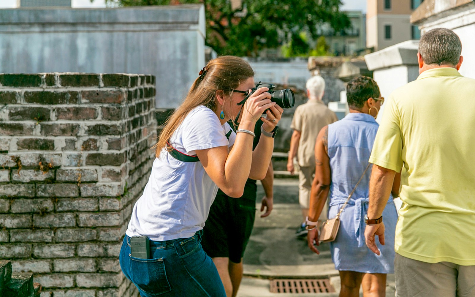 Guests exploring St. Louis Cemetery with a photographer capturing the scene.