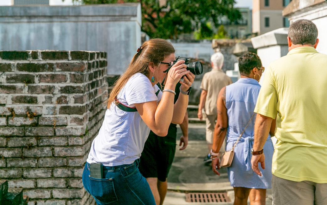 Guests exploring St. Louis Cemetery with a photographer capturing the scene.