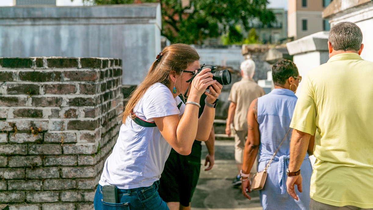 Guests exploring St. Louis Cemetery with a photographer capturing the scene.