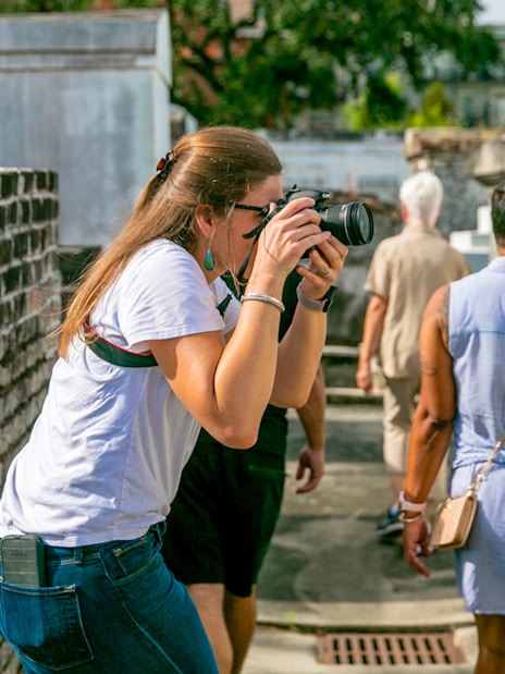 Guests exploring St. Louis Cemetery with a photographer capturing the scene.