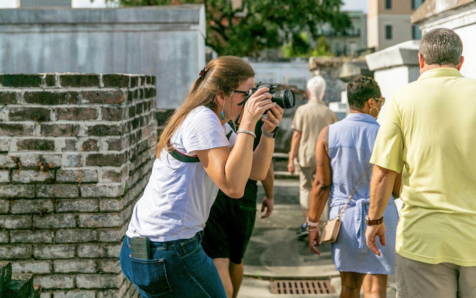 Guests exploring St. Louis Cemetery with a photographer capturing the scene.