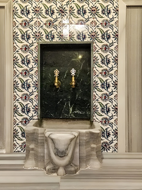 Gedikpasa Historical Hammam marble basin with ornate tile backdrop.