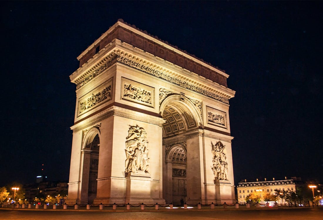 Arc de Triomphe illuminated at night on Charles de Gaulle Square, Paris.