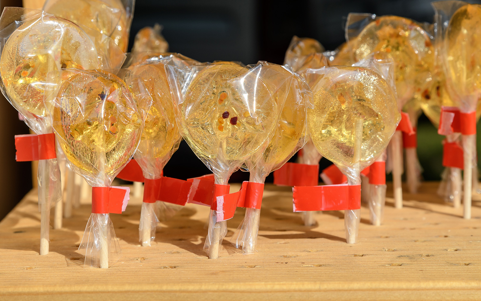 Honey infused lollipop held against the backdrop of a vibrant cityscape in New York City.