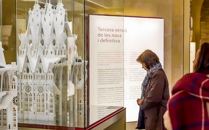 Sagrada Familia museum visitor observing architectural model display.