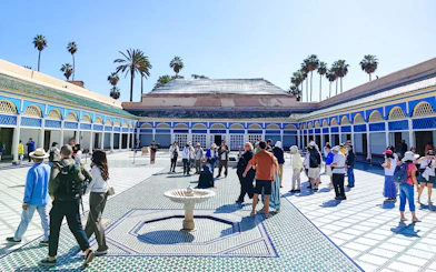 Visitors exploring the courtyard of Bahia Palace in Marrakech, Morocco.