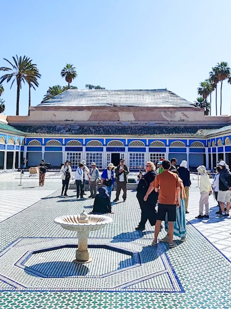Visitors exploring the courtyard of Bahia Palace in Marrakech, Morocco.