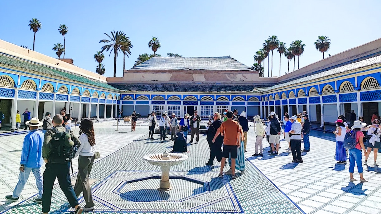Visitors exploring the courtyard of Bahia Palace in Marrakech, Morocco.