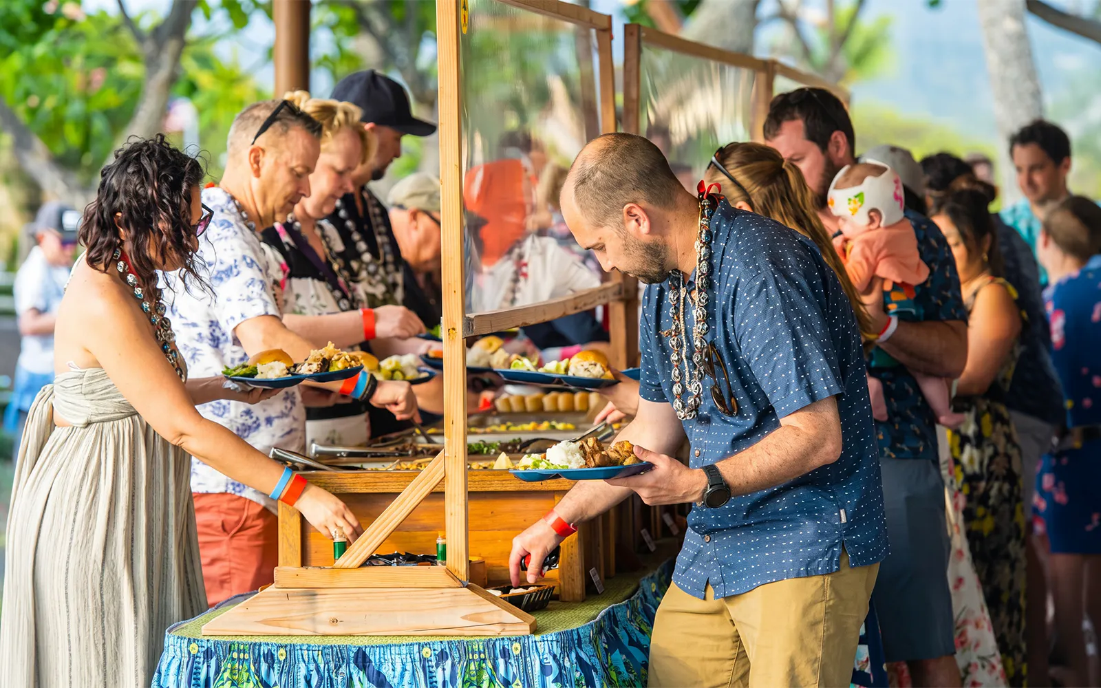 Guests serving themselves at a buffet during Voyagers of the Pacific Luau in Hawaii.