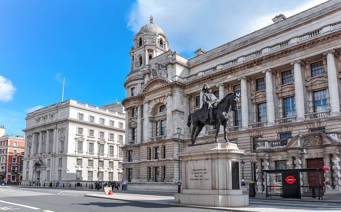 Equestrian statue in front of historic London building near Westminster.