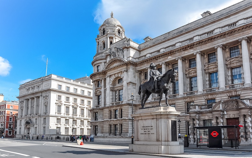 Equestrian statue in front of historic London building near Westminster.