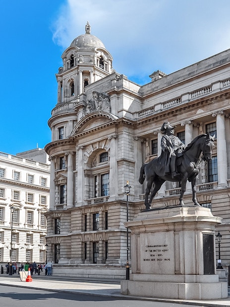Equestrian statue in front of historic London building near Westminster.