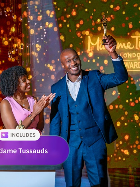 Wax figure of The Rock at Madame Tussauds London with two people celebrating an award.