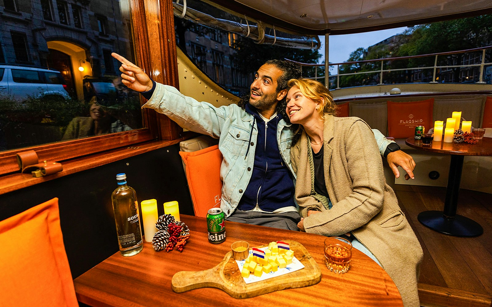 Guests enjoying wine and cheese on a luxury canal cruise in Amsterdam.